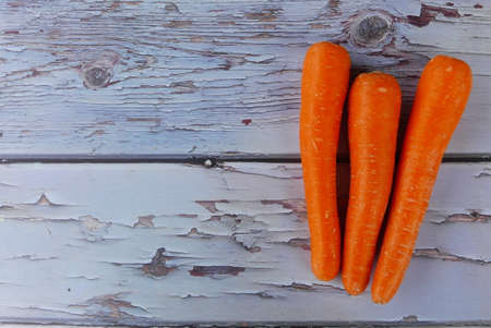 Top view of carrot on wooden background. Copy space for text or logo.