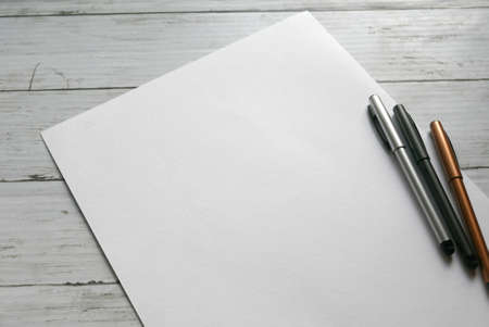 three pen on white paper background lay on white wooden background. Copy paste for text, logo and etc.の写真素材