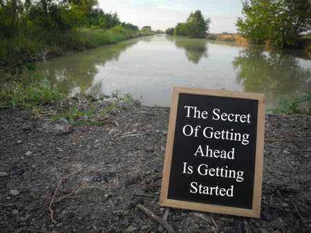 Inspirational motivational quotes written on blackboard with nature background. The secret of...