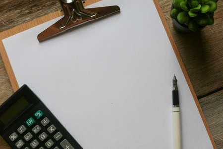 Clipboard with white paper with stationery on wooden background. Copy space for text or logo.の写真素材