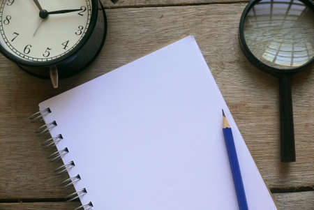 Notebook with stationery on wooden background. Copy space for text or logo.