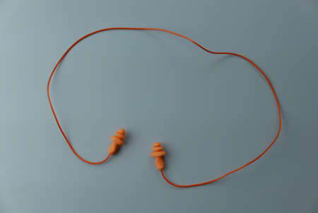 Yellow hearing safety protection earplug isolated on a grey background.の写真素材