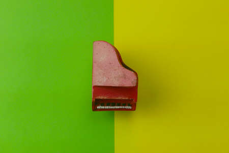 Top view of red toy piano on a two color background which are green and yellow.の写真素材
