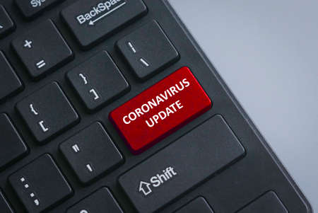A black keyboard with red button written with Coronavirus Update as per current situation of...