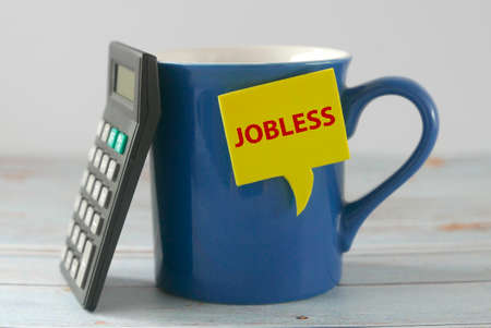Concept of jobless with calculator lean on a blue mug. Unemployment issue concept