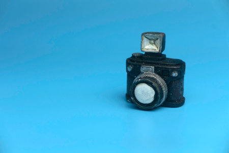 Selective focus of miniature camera isolated on a blue background with a copy space.