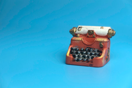 Selective focus of miniature typewriter isolated on a blue background with a copy space.の写真素材