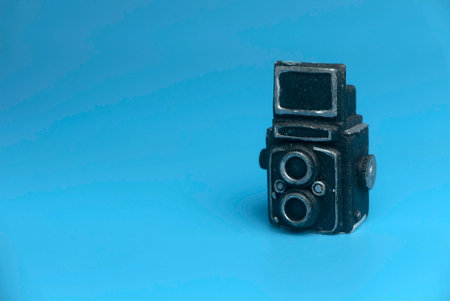 Selective focus of miniature camera isolated on a blue background with a copy space.