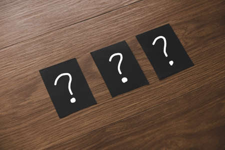 Three black paper written with question mark symbol.の写真素材