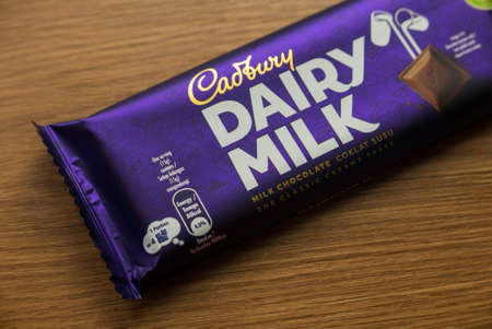 KEDAH,MALAYSIA - MARCH 6TH,2021 : Cadbury Dairy Milk chocolate bar on wooden background. Cadbury Dairy Milk is a brand of milk chocolate manufactured by Cadbury.のeditorial素材