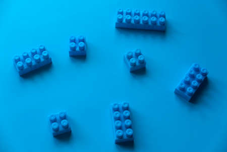 Blue plastic building blocks on blue background.の写真素材