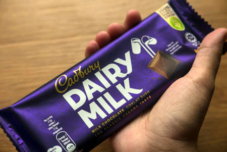 KEDAH,MALAYSIA - MARCH 6TH,2021 : A hand holding Cadbury Dairy Milk chocolate bar. Cadbury Dairy Milk is a brand of milk chocolate manufactured by Cadbury.のeditorial素材