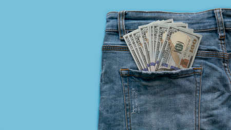 Dollar money in a pocket of blue jeans.