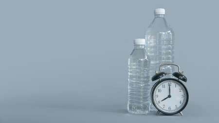 A plastic bottle of drinking water and vintage alarm clock isolated on grey background with copy space.の写真素材