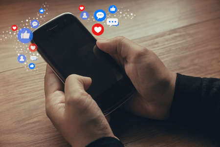 Hand holding smartphone with social media icon. Concept of social media and digital online.