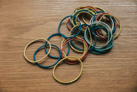 colourful multi coloured elastic rubber bands on wooden background.の写真素材