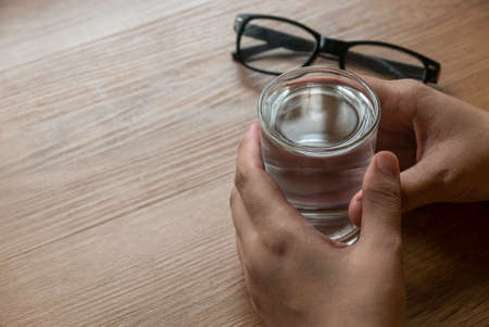 Hand holding a glass of plain water for drinking.の写真素材
