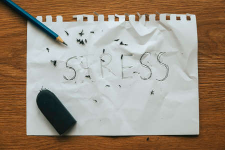 Stress relief and management concept.pencil with eraser strokes word stress on white paper.の写真素材