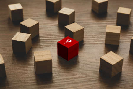 Selective focus of red wooden cube written with Question symbol on wooden background.の写真素材