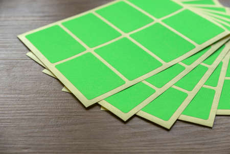 A set of green rectangular paper sticker label on wooden background.の写真素材