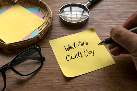 Selective focus of hand writing What Our Clients Say on a yellow paper.の写真素材