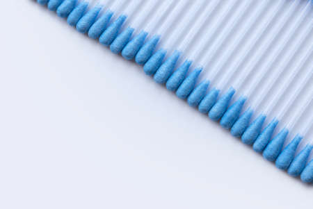 A row of cotton buds on a white background.の写真素材