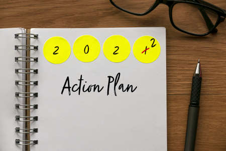 Green label sticker written with Year 2022 on a notebook written with Action Plan.の写真素材