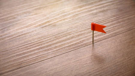 Red color flag pin isolated on a wooden background with copy space.の写真素材