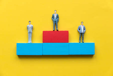 Miniature business people standing on a podium. Business reward concept.の写真素材