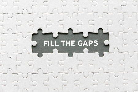 Top view of an empty space of jigsaw puzzle fill with a phrase Fill The Gaps.