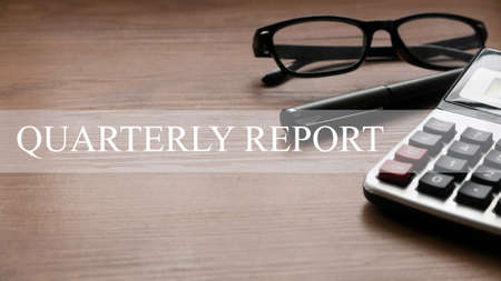 Quarterly report concept with glasses,pen and calculator on wooden background.の写真素材