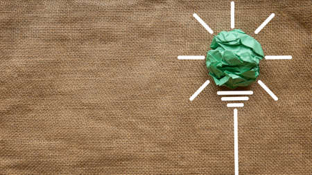 Inspiration concept. A green crumpled paper ball with a light bulb icon.の写真素材