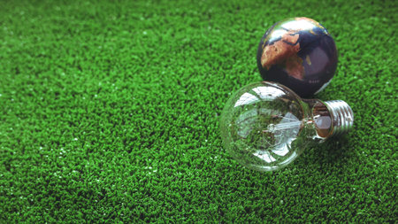 Light bulb and a miniature earth on the green grass.The concept of energy saving, renewable energy and environmentally friendly.の写真素材