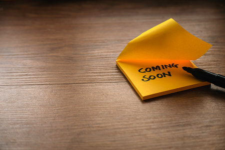 Coming soon written on a yellow paper with a black marker pen.