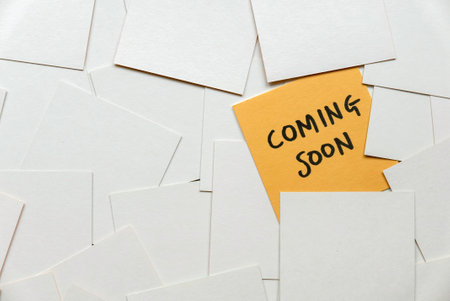 A yellow card among an empty white card written with coming soon.