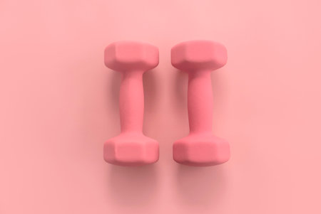 Fitness and healthy sport concept. Pink dumbbell on a pastel pink background.の写真素材