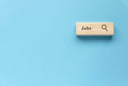 Searching for a new job, employment, a career, a job opportunity, or a work position concept. Wooden search bar isolated on a blue background with copy space.の写真素材