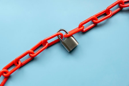 Safety concept. Red chain and padlock on blue background.の写真素材