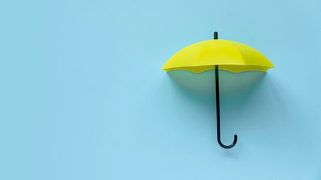 Yellow umbrella over a blue background. Banner with copy space.