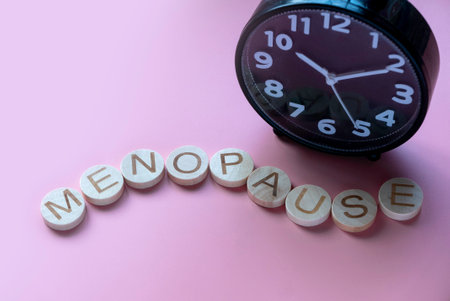 Alphabet form a word menopause over a clock. Healthcare and medical concept for women. Pink backgroundの写真素材
