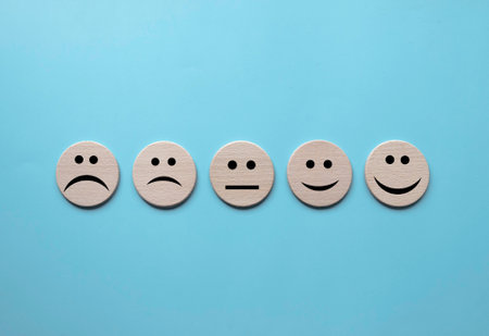 Concept of Customer Satisfaction Survey, user rate, service evaluation. Face expression on wooden...