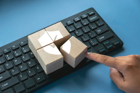 Wooden cube with shield  and check mark over a computer keyboard.Concept of technology internet, cyber security, database and web protection concept.の写真素材