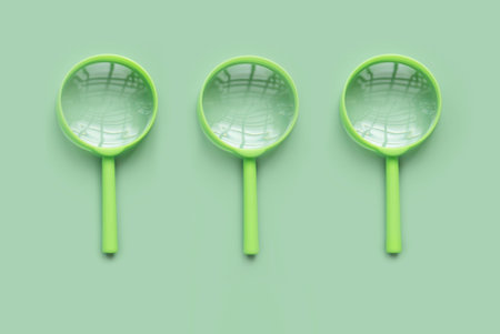 Green magnifying glass over a green background.