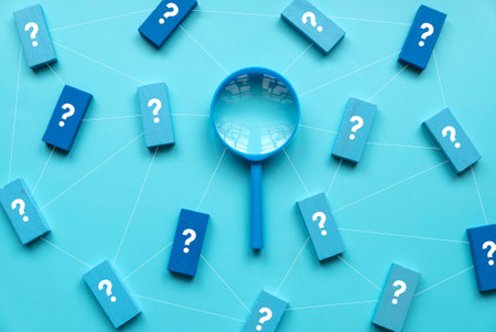 QnA or questions and answers concept. Blue magnifying glass with question symbol on wooden cube over a blue background.の写真素材