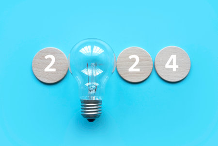 New year concept. Bulb with wooden circle written with number.