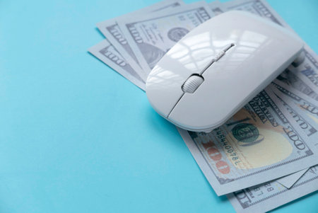 Concept of Technology, business and finance. Computer mouse over a dollar cash money.の写真素材