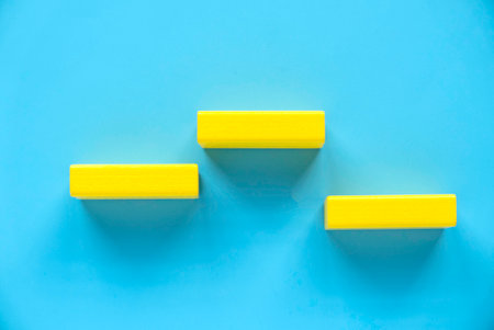 Winner podium, stage or pedestal. Yellow wooden block over a blue background.の写真素材