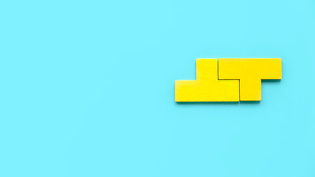 Top view two piece of yellow puzzle isolated on a blue background with copy space.の写真素材