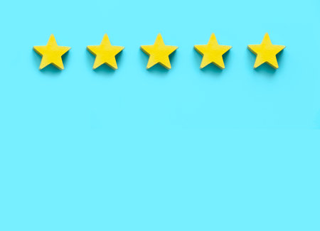 Client feedback, product rating, customer experience satisfaction. Five yellow wooden star on blue...