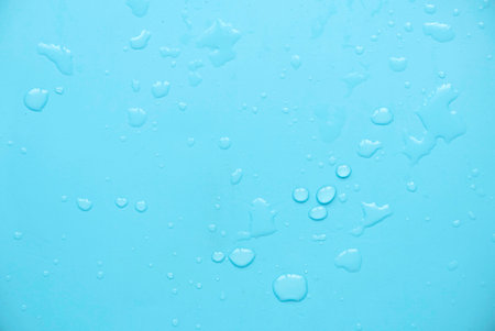 Water drops over a blue background for creative poster design.